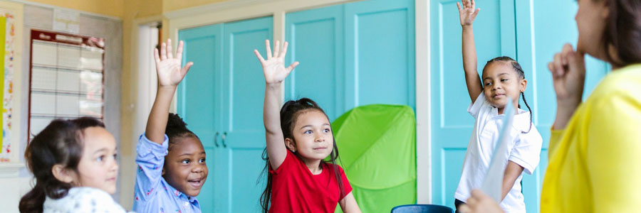 Kids raising their hands in class