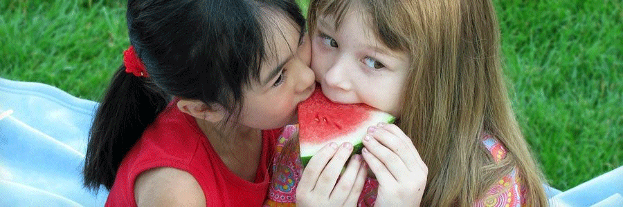 Two kids sharing a watermelon slice