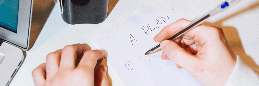 Person writing a plan on paper